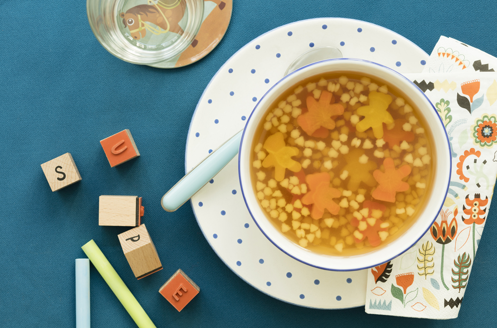 Bunte Gourmelino-Suppe auf blauem Untergrund