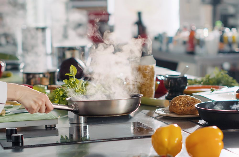 Gastronomieküche mit Pfanne am Herd